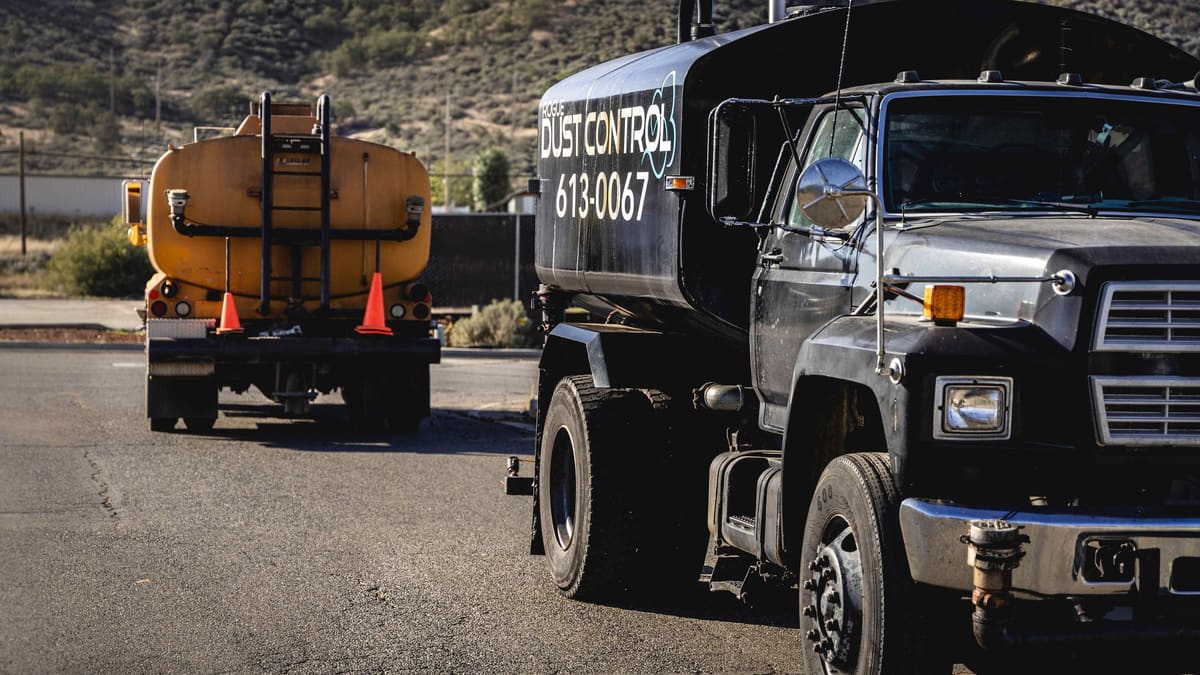 The black tanker in front, the yellow tanker parked behind it.